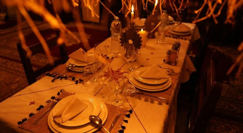 Candle-lit dinner table set with plates and glasses