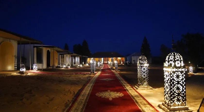 Red carpet path lined with tall carved lanterns at night